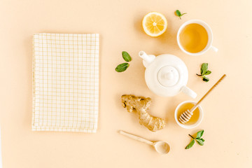 Herbal tea with mint, ginger, lemon, honey and other herbs on yellow background. Flat lay, top view.