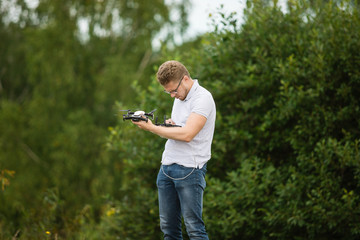 The young man manipulates the drone using the control panel. New technologies and trends in photo and video recording. record footage in the air.