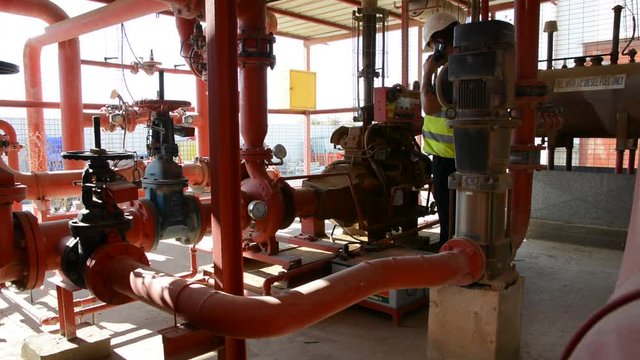 Engineer inspecting machinery water pump. checks the pump sprinklers