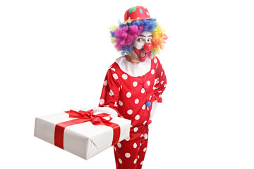 Funny clown holding a gift box and making a grimace