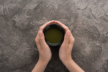 top view of woman holding matcha matcha tea in hands