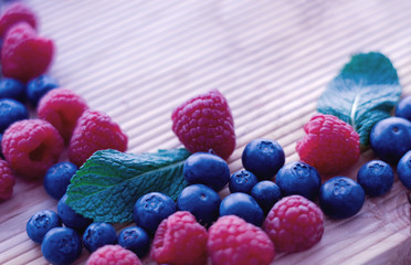 Berries frame on a wooden background, blueberry, raspberries