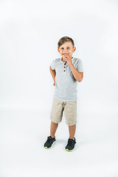 Little boy with autism standing on a white background feeling happy and smiling