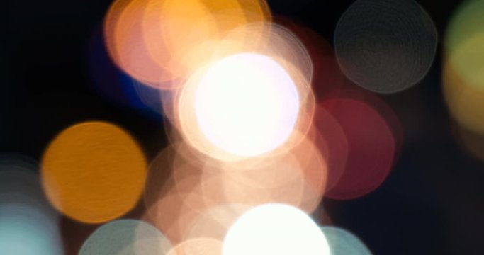 Defocused, blurred bokeh and abstract blurred light of car on street. Royalty high-quality free stock video footage of traffic light, glowing backdrop overlay for design. Traffic light in city night