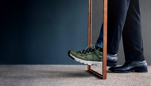 Work Life Balance Concept. Challenging To Change. Low Section Of Businessman Steps Passing A Wooden Frame. Half Is A Formal Dress And Other Side Is A Casual Traveling Shoes