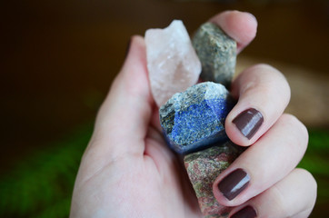 Rough crystals in woman's hand with natural lighting. Raw Rose Quartz, Raw Lapis Lazuli, Raw...