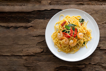 Seafood spaghetti with shrimp on a wooden background.