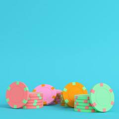 Colorful casino chips on bright blue background in pastel colors