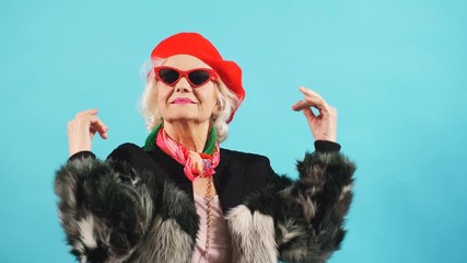 Beautiful elderly charming woman in dark sunglasses looking at the camera. Lifestyle, free time.