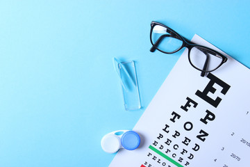 a table for checking vision, glasses and lenses for correcting vision on a colored background, top view. Ophthalmologist Accessories. © White bear studio 