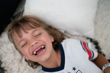 Overhead view of child laughing with missing teeth