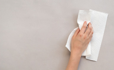 Woman wiping table with paper towel	