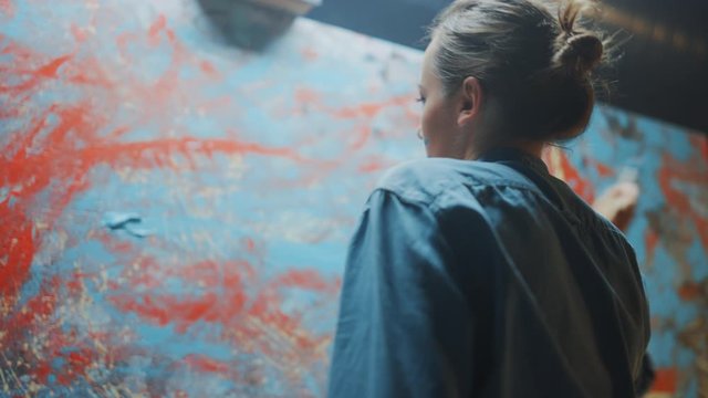 Talented Innovative Female Artist Picks up Paint Brush and Starts Drawing Colorful, Emotional, Sensual Oil Painting. Contemporary Painter Creating Abstract Modern Art in Her Studio