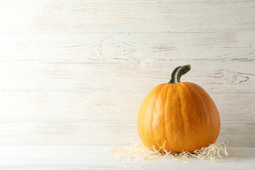 Pumpkin on white wooden background, space for text