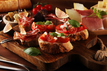 Italian antipasti wine snacks set. Cheese variety, Mediterranean olives, Prosciutto di Parma, tomatoes, artichokes