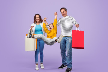 Parents swinging son after shopping