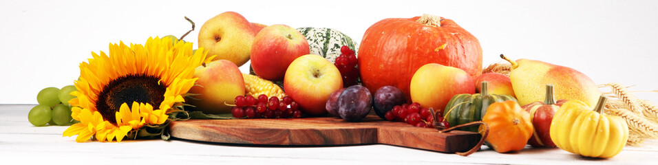 Autumn nature concept. Fall fruit and vegetables on wood. Thanksgiving dinner and sunflower