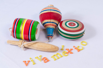 Fototapeta na wymiar Balero, spin and yoyo, colorful wooden mexican toys and Viva Mexico made from colorful letters on white background