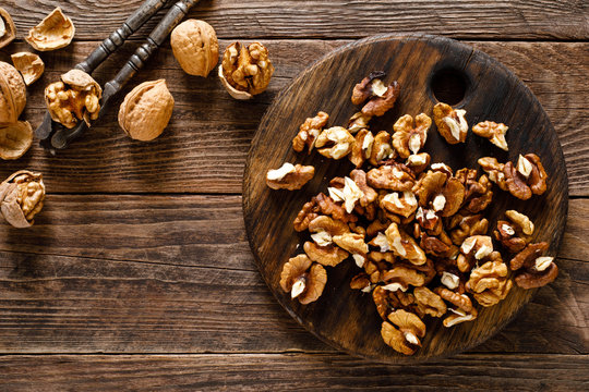 Walnuts. Kernels and whole nuts on wooden rustic table, top view