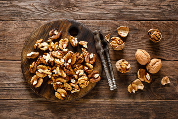 Walnuts. Kernels and whole nuts on wooden rustic table, top view