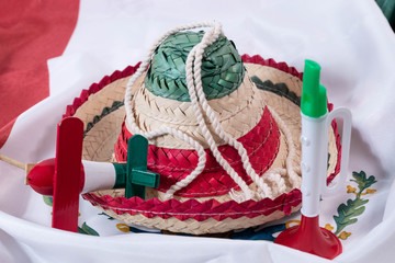 Hat, noisemaker and trumpet, accessories for Mexican Independence Day celebration on a mexican flag