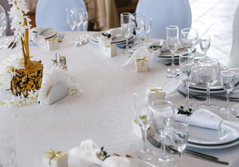 banquet table setting, decorated with a bouquet of white flowers in the center of the table