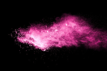 Pink powder explosion on black background. Paint Holi.