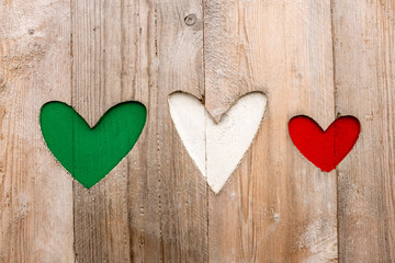 three hearts cut out on wooden backdrop