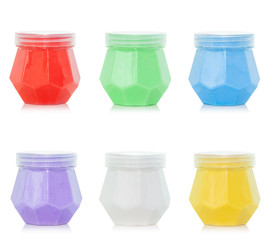 colored jars with plasticine on a white background