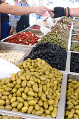 Various marinated olives for sale in a market window.