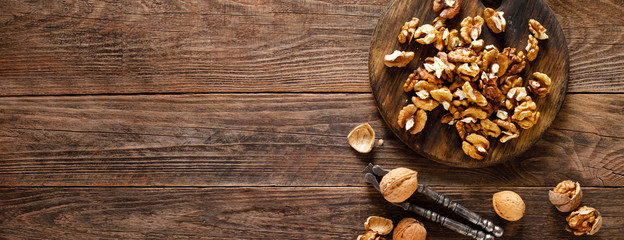 Walnuts. Kernels and whole nuts on wooden rustic table, banner, top view