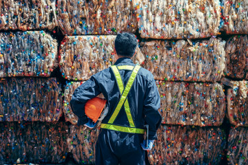 Engineer Standing and looking back The plastic bottle in the recycling industry - obrazy, fototapety, plakaty