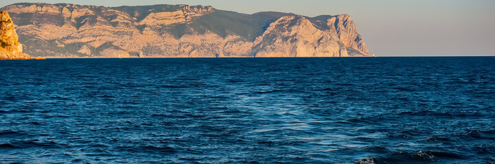 Obraz premium Seascape Water, Mountains and Yacht in the evening.