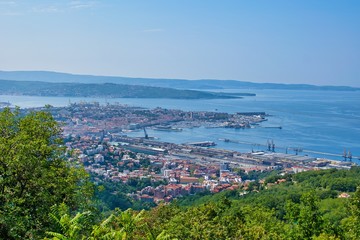 Fototapeta na wymiar Italy city - Trieste industrial area with red buildings and port. Sea and mountains in the background.Panoramic aerial view.