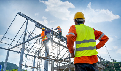 Engineer technician watching team of workers on high steel platform,Engineer technician Looking Up...