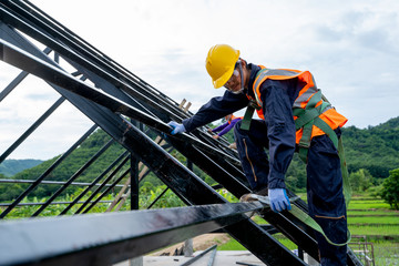 Construction worker wearing safety harness using secondary safety device connecting into 15 mm...