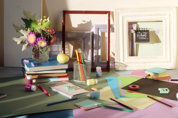 Books, flowers, apple, stationery, frames and colored paper on the table, education, back to school, summer, autumn