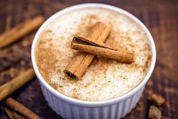 Sweet decorated with cinnamon. Brazilian tasty dessert on wood background.