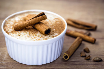 Cinnamon rice porridge in a bowl on a light wooden background. Food viewed from the top