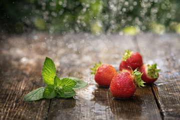 strawberries in the rain on a wooden table close-up