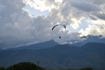 Man flies on his paraglider with a spectacular view of the mountains