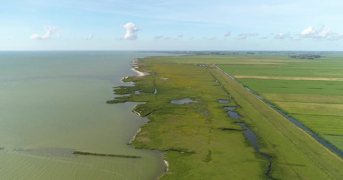 Dutch Nature at the IJsselmeer, Green Fields, Clouds and Water, Friesland, The Netherlands / Holland 4K Drone Footage