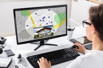 Businesswoman Calculating Invoice On Computer