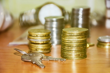 keys on the background of coins, watches and money. Close-up. Keys on a wooden table.