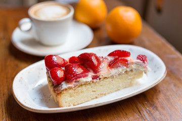 Close up strawberry cake and coffee latte art. Still life with a Cup of coffee and sweet dessert with strawberries