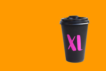 Disposable cardboard black cup isolated on orange background, Eco cup for hot drinks, Copy space