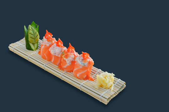 Salmon sashimi roll with sauce. Black background