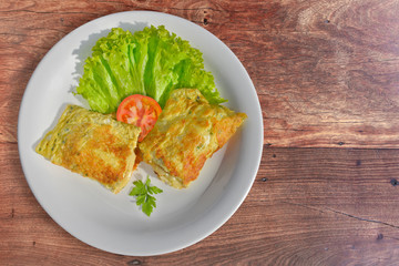 Omelet stuffed with melted cheese and salad