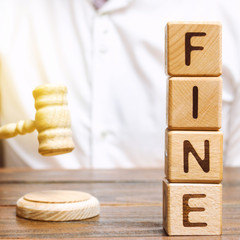 Wooden blocks with the word Fine and judge. Penalty as a punishment for a crime and offense....