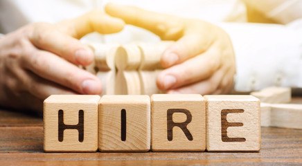 Wooden blocks with the word Hire. Headhunter selects a person from the crowd. Good choice. Human Resource Management. Recruiting Headhunting. Hiring employees. Attracting people to work